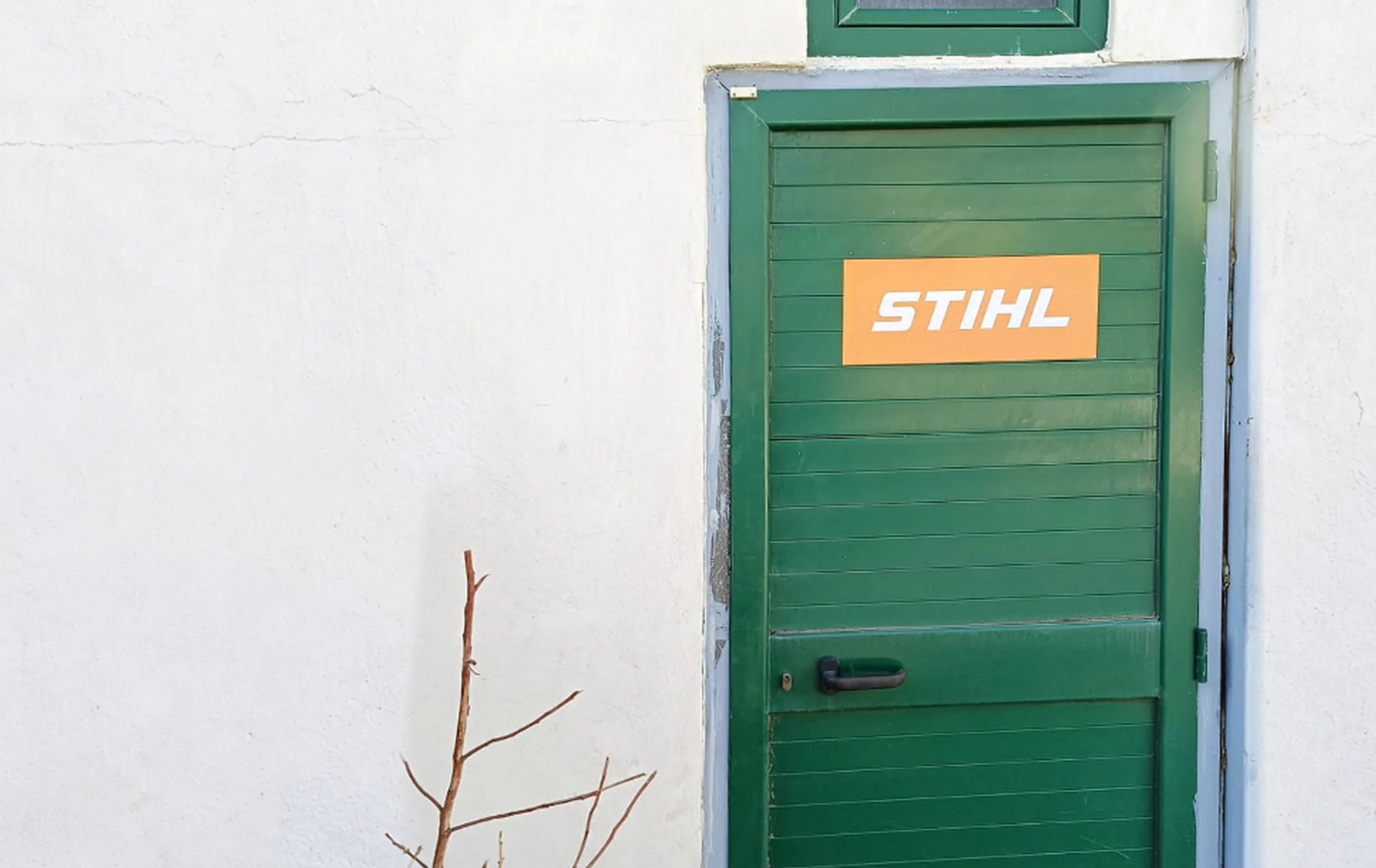 La porta verde dell'officina, con l'adesivo Stihl