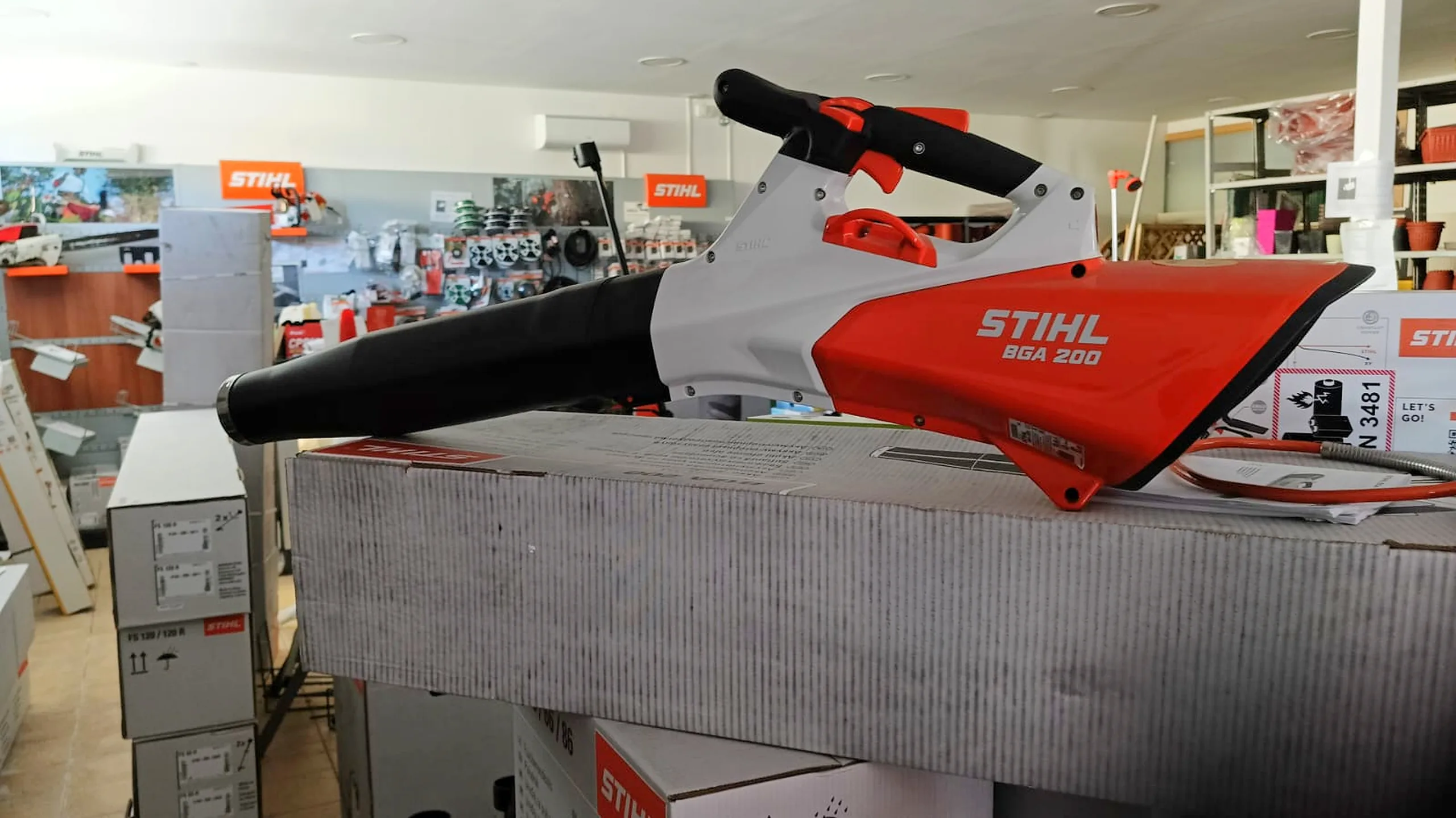Il soffiatore a batteria Stihl BGA 200 sul banco del negozio, davanti agli scaffali