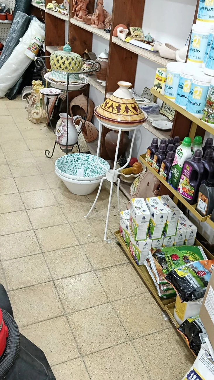 L'interno del negozio, con vasi, ceramiche e concimi sugli scaffali