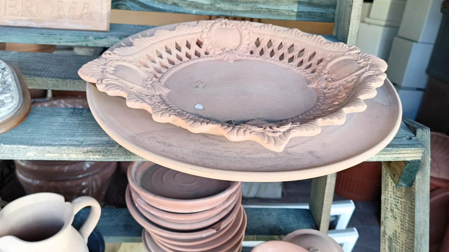 Un cesto ovale in terracotta traforata, sullo scaffale del negozio