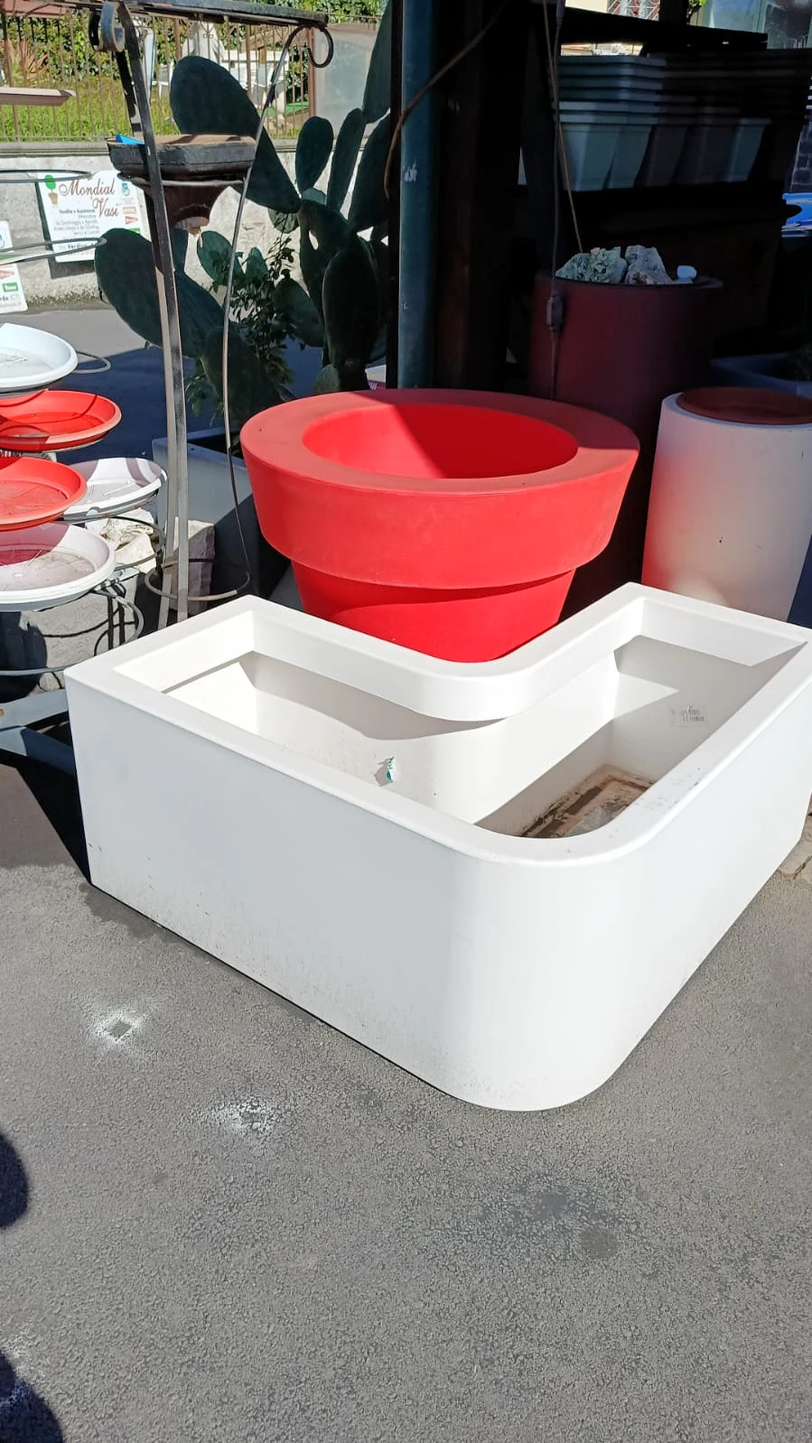 Un vaso rosso e una fioriera bianca ad angolo in resina